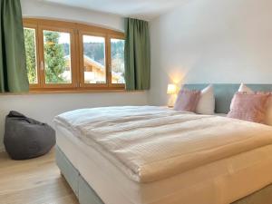 una camera da letto con un grande letto e una finestra di Apartmenthaus am Tegernsee - Studios mit Küchenzeile und mit Bus erreichbar a Bad Wiessee