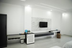 um quarto branco com uma televisão na parede em Le Phan Hotel em Tây Ninh