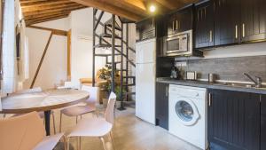 uma cozinha com uma mesa e uma máquina de lavar roupa em Madera y Piedra em Toledo