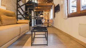uma sala de estar com um sofá e uma mesa em Madera y Piedra em Toledo