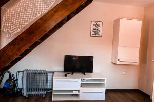 una sala de estar con TV en un vestidor y una escalera en Mad House Apartment 2, Terme Čatež, en Brežice