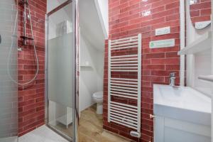 bagno con doccia e parete di mattoni rossi di BENFLEET 2 Cocooning studio Proche Paris a Romainville