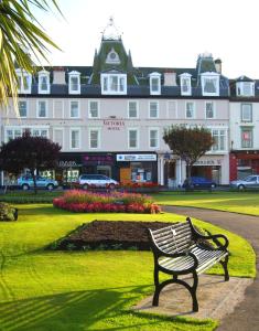 a park bench in front of a large building at The Victoria Hotel in Rothesay