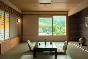 藏王溫泉的住宿－高宮光亮酒店，客房设有桌椅和窗户。