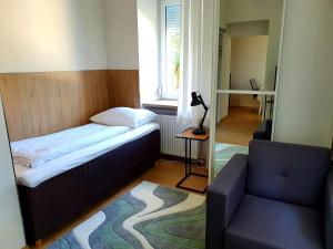 ein kleines Schlafzimmer mit einem Bett und einem Sofa in der Unterkunft Hotel Hotwagner in Maria Enzersdorf