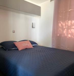 a bedroom with a blue bed with a pink pillow at Roccapina in Lumio
