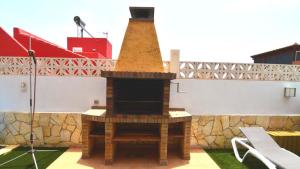 una chimenea en la parte superior de un edificio con una mesa en Villa Majorera Private Pool Corralejo By Holidays Home, en Corralejo