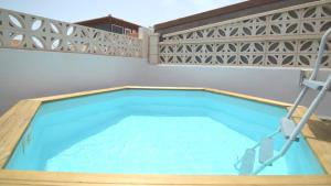 una gran piscina cubierta con marco de madera y una piscina de madera en Villa Majorera Private Pool Corralejo By Holidays Home, en Corralejo