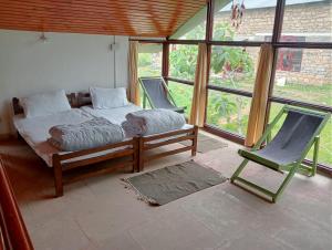 1 dormitorio con 1 cama, 1 silla y 1 ventana en THE SILVER OAK PLACE, en Pithorāgarh