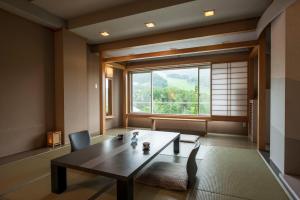 a room with a table and a large window at Takamiya Hotel Lucent in Zaō Onsen