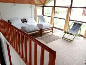 a bedroom with a bed and a chair in a room at THE SILVER OAK PLACE in Pithorāgarh