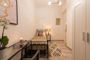 Cette petite chambre comprend un lit et une table. dans l'établissement Apartments Florence-4 bedroom in Pellicceria (sx), à Florence