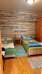 a bedroom with two beds and a wooden wall at Mandula Apartman in Szeged