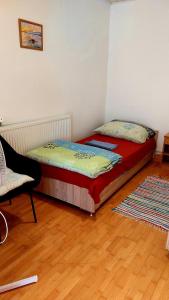 1 dormitorio pequeño con 1 cama y 1 silla en Mandula Apartman, en Szeged