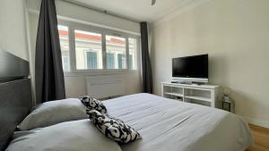 Schlafzimmer mit einem Bett und einem Flachbild-TV in der Unterkunft Superbe 2 Pièces à cannes plage Festival ! in Cannes