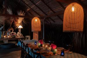 a dining room with a table with chairs and lights at Luna Laguna in Kalpitiya