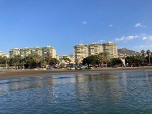 a view of a beach with buildings in the background at Calle Quitapenas 37 in Málaga