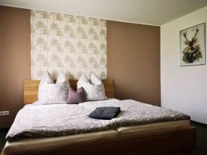 1 dormitorio con 1 cama grande con almohadas blancas y moradas en Landhaus Kirchberg en Nardt