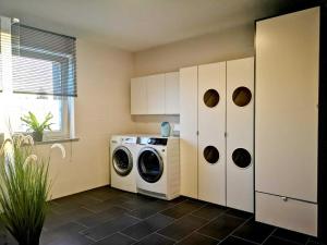 a laundry room with a washer and a washing machine at Landhaus Kirchberg in Nardt