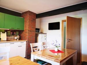 a kitchen with green cabinets and a table with a red napkin at Landhaus Kirchberg in Nardt