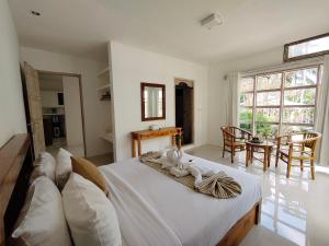 a bedroom with a bed and a table with chairs at Aventus Resort Ubud in Tegalalang
