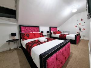 two beds in a room with red and white at *F43NH* Setup for your most relaxed & Cosy stay + Free Parking + Free Fast WiFi * in Belle Isle