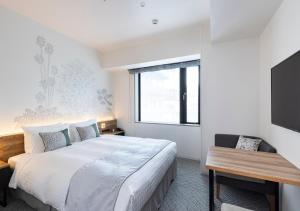 a bedroom with a large bed and a television at Tokyu Stay Shinjuku Eastside in Tokyo