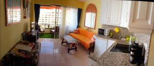 a kitchen with an orange couch in a living room at Apartamento Osos in Puerto de Santiago