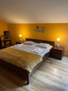 1 dormitorio con 1 cama grande, 2 mesas y 2 lámparas en Penzión Turzov en Gelnica