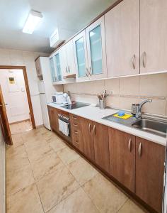 a kitchen with wooden cabinets and a sink at El Palmar in Murcia