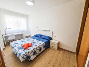 a bedroom with a bed with blue and orange pillows at El Palmar in Murcia