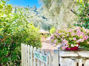 a white picket fence with flowers in a garden at Villa Eva Agni with private pool by DadoVillas in Agní