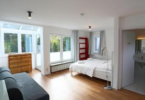 a bedroom with a bed and two windows at Relaxing 140m2 Holiday Home South of Munich - 25 Min to Center - Fully Equipped in Baierbrunn