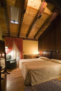 um quarto com uma cama grande e uma cadeira em Hotel Hospital de Benasque em Benasque