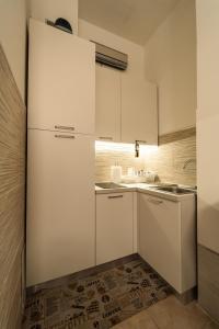 a kitchen with white cabinets and a sink at Sole Luna B&B in Pescara +23 photos