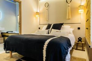 1 dormitorio con 1 cama en blanco y negro con espejo en Host Inn Le Lumiere SPA & CINÉMA, en Lyon
