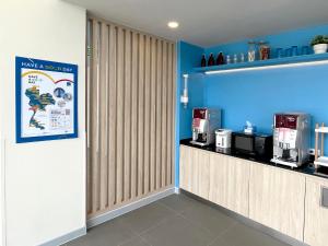 een koffiebar met een bar en blauwe muren bij Hop Inn Bangkok Bangna in Bangkok