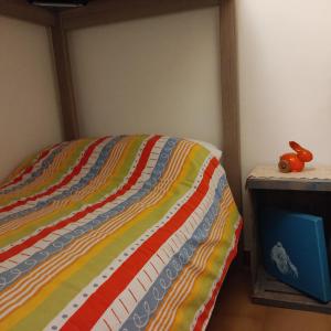 1 dormitorio con 1 cama con un edredón colorido en La Casa di Allo, en Charvensod