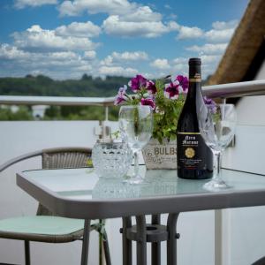 a table with a bottle of wine and glasses at Ferienwohnung Sonnenblick in Losheim am See in Losheim