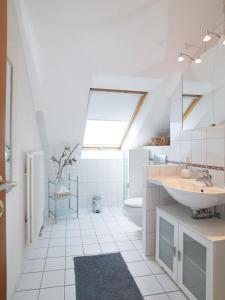La salle de bains est pourvue d'un lavabo, de toilettes et d'une lucarne. dans l'établissement Ferienwohnung Sonnenblick in Losheim am See, à Losheim