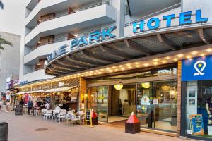 a store front of a hotel with tables and chairs at Hotel Xaine Park in Lloret de Mar