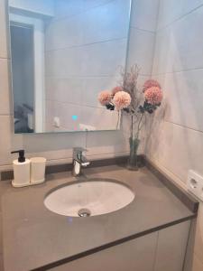 a bathroom with a sink and a vase of flowers at El rincón de Manolita. #2 in Bornos