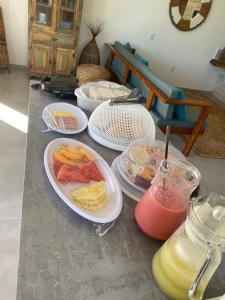 a table with plates of food and a drink at Vila Gará Kite House - Ilha do Guajiru in Itarema