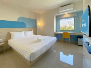 een slaapkamer met een bed, een bureau en een televisie bij Hop Inn Bangkok Bangna in Bangkok