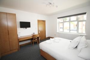 um quarto com uma cama, uma secretária e uma televisão em Flexistay Aparthotel Sutton em Sutton