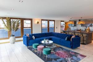 ein Wohnzimmer mit einem blauen Sofa und einem Tisch in der Unterkunft Posh Pads - Liverpool 1 - Apart-Hotel in Liverpool