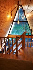 ventana grande en una habitación con techo de madera en Casa - Cabana Tip A Frame, Cerna, Vaideeni, Valcea, en Cerna