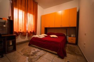 a bedroom with a bed with red sheets and orange cabinets at Sole Luna B&B in Pescara