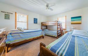 a bedroom with two beds and a bunk bed at Sound Waves in Duck +125 photos