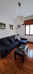 a living room with a blue couch and a coffee table at Apartamento Jarrillero in Portugalete